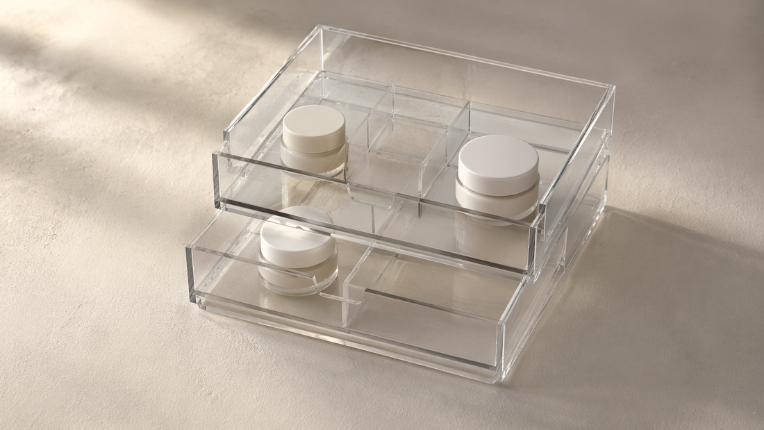 Acrylic drawer organizer with spaced items in separate compartments and visible empty sections