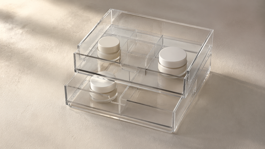 Acrylic drawer organizer with spaced items in separate compartments and visible empty sections