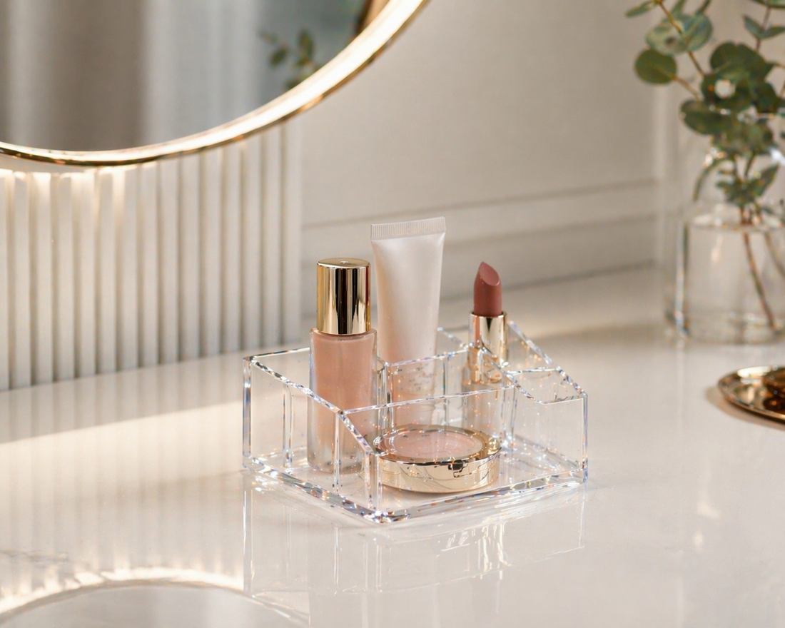 Minimal acrylic makeup organizer with 2–3 items grouped in a defined zone to prevent clutter spread on a small vanity surface.