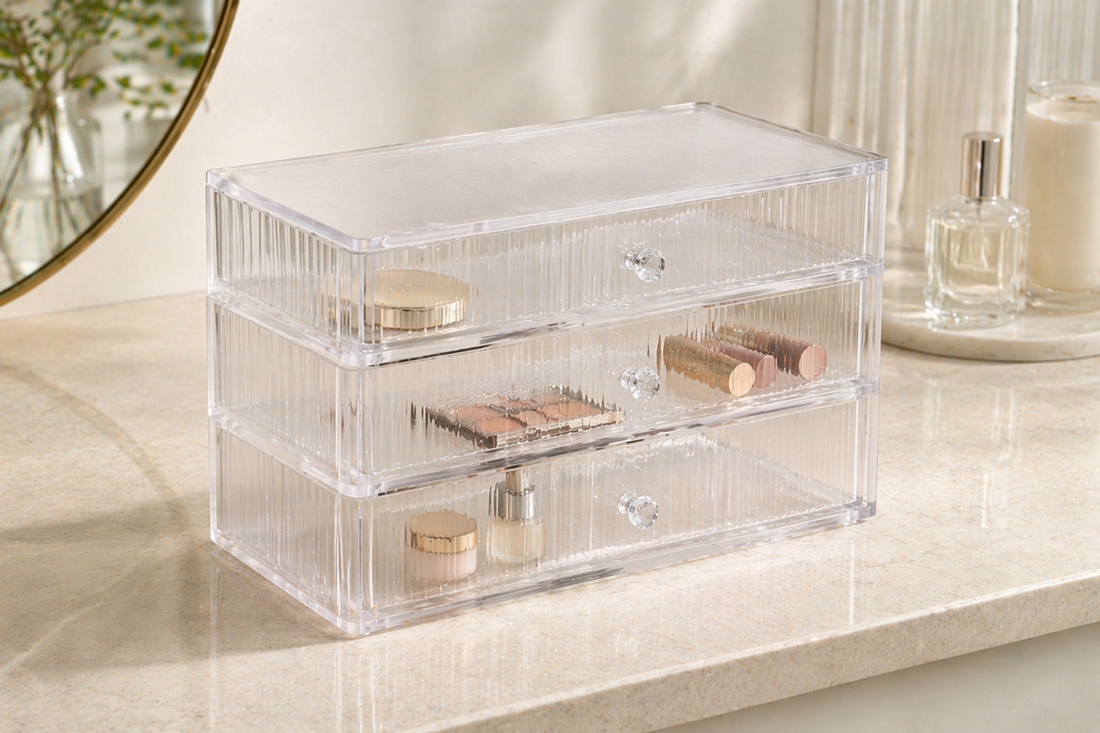 Clear acrylic drawer organizer with divided compartments separating cosmetics for compact and structured storage.