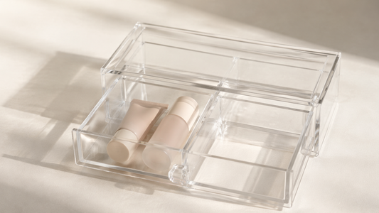Clear acrylic drawer organizer showing one section used and adjacent compartments empty for structured separation