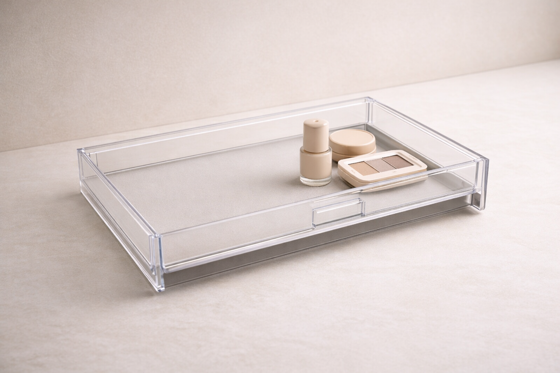 Grouped makeup items in a clear acrylic drawer placed in a tight cluster with wide empty space to improve access speed.