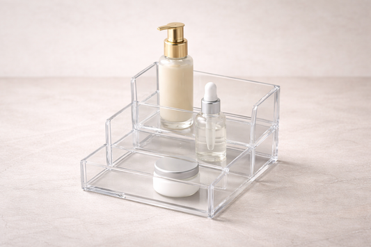 Clear acrylic tiered organizer with 3 skincare bottles arranged by height difference for improved vertical accessibility and visibility.