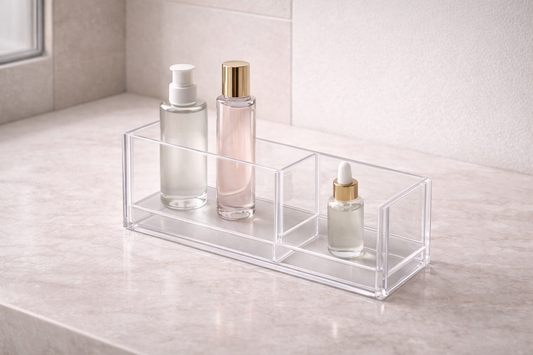 Clear acrylic organizer with height-graded skincare bottles placed in separate compartments, showing vertical access flow and structured spacing for fast retrieval