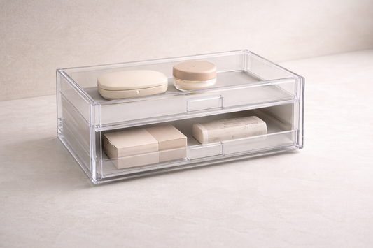Two-tier acrylic drawer system with daily items in the upper drawer and backup products in the lower drawer, creating clear storage hierarchy.