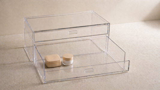 Acrylic drawer with minimal items in one zone and wide empty space preserving stable placement and reducing repeated adjustments.