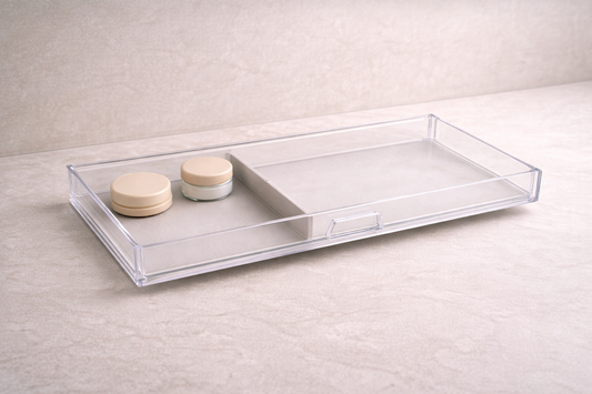 Minimal acrylic drawer layout with two low-profile items placed to one side and wide empty space to reduce clutter.