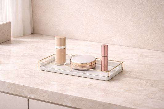Minimal makeup organizer with three items spaced apart on a clean vanity surface to maintain a clutter-free layout