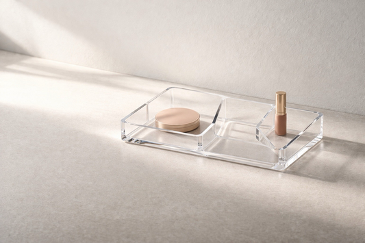 Quick makeup organization ideas featuring a clear acrylic tray with divided sections on a marble vanity