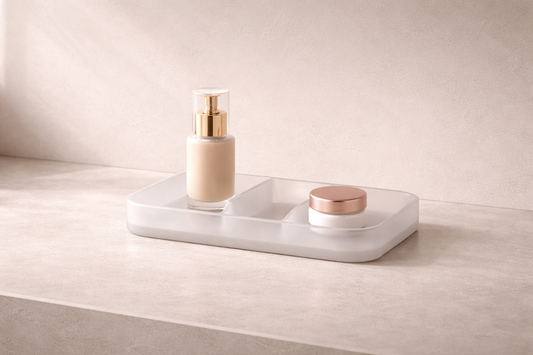 Quick skincare storage for faster daily routines featuring a frosted white minimalist tray holding a foundation bottle and small cream jar on a neutral countertop