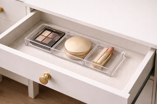 Low-profile makeup organizer with flat items arranged in separate compartments inside a shallow drawer