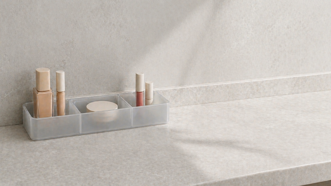 Makeup organizer arranged on a small vanity with clear grouping.