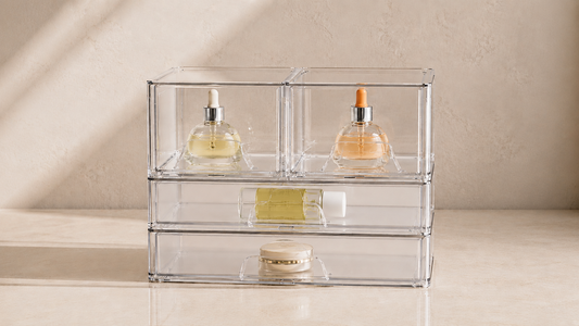 Transparent drawer organizer with separated beauty products and open spacing.