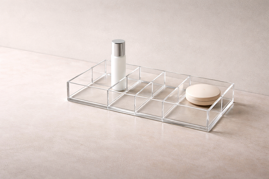 16:8 wide header image of a zoned acrylic vanity layout on a matte stone surface with strong air gaps between items.