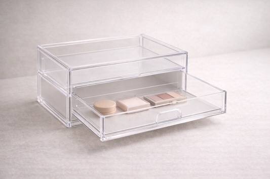 Clear acrylic drawer organizer with low-profile skincare items arranged in a single drawer layer and visible empty space.
