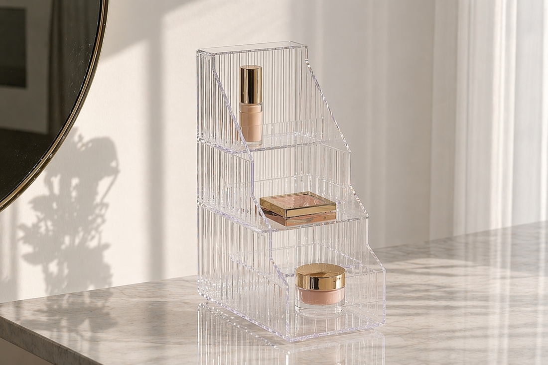 Tiered acrylic makeup organizer maximizing vertical space on a small vanity with clear separation.