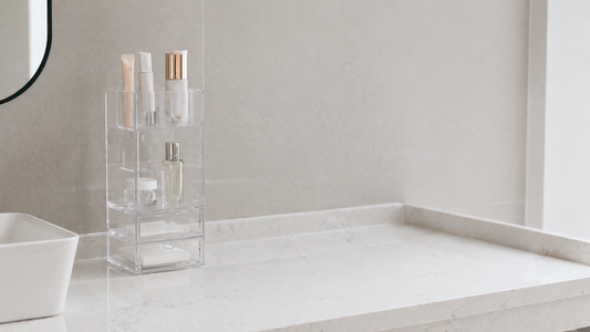 Slim acrylic organizer with vertical layers and clear separation, using minimal items to optimize narrow bathroom vanity space.